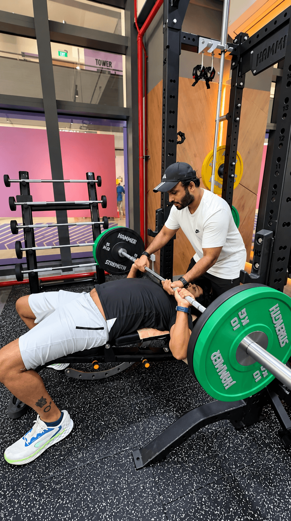 Coach Binish guiding a client during strength training